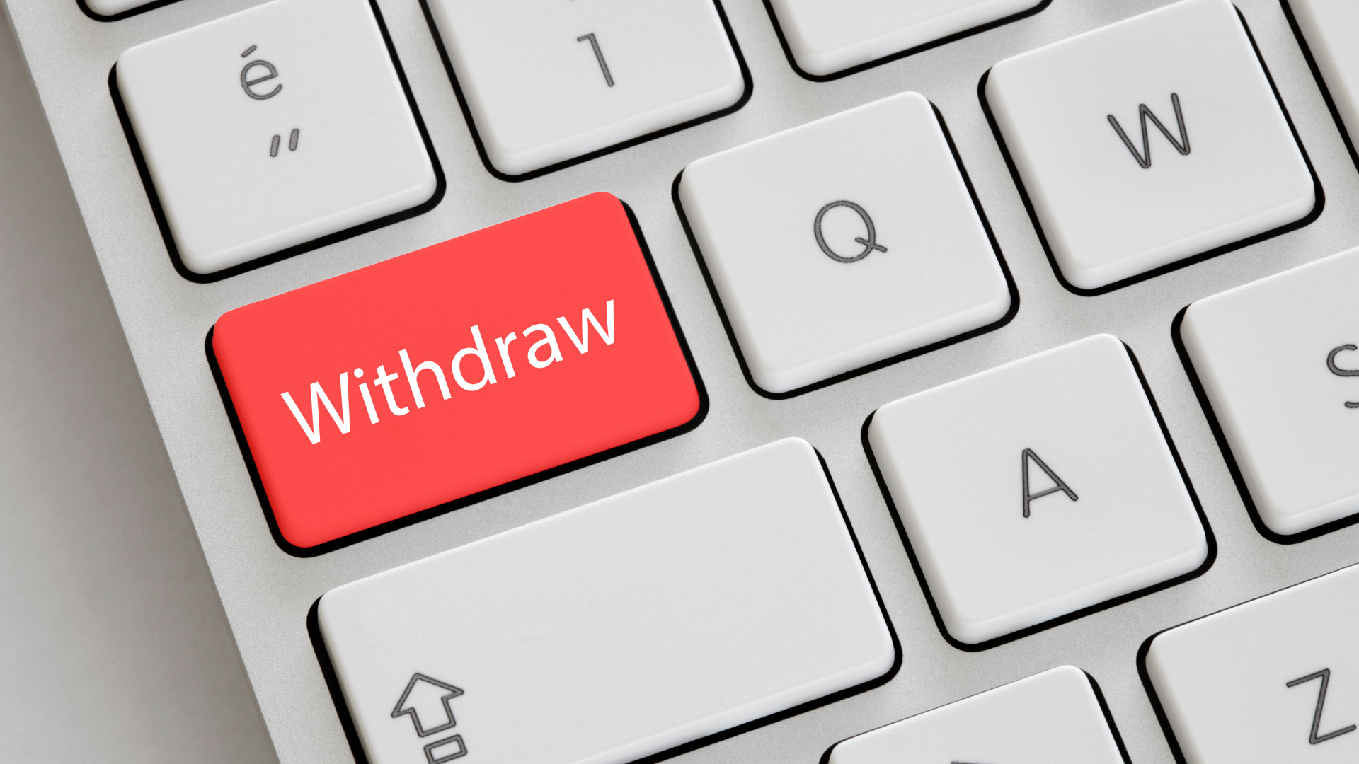 Close up of computer keyboard with a red key with withdraw in white letters.