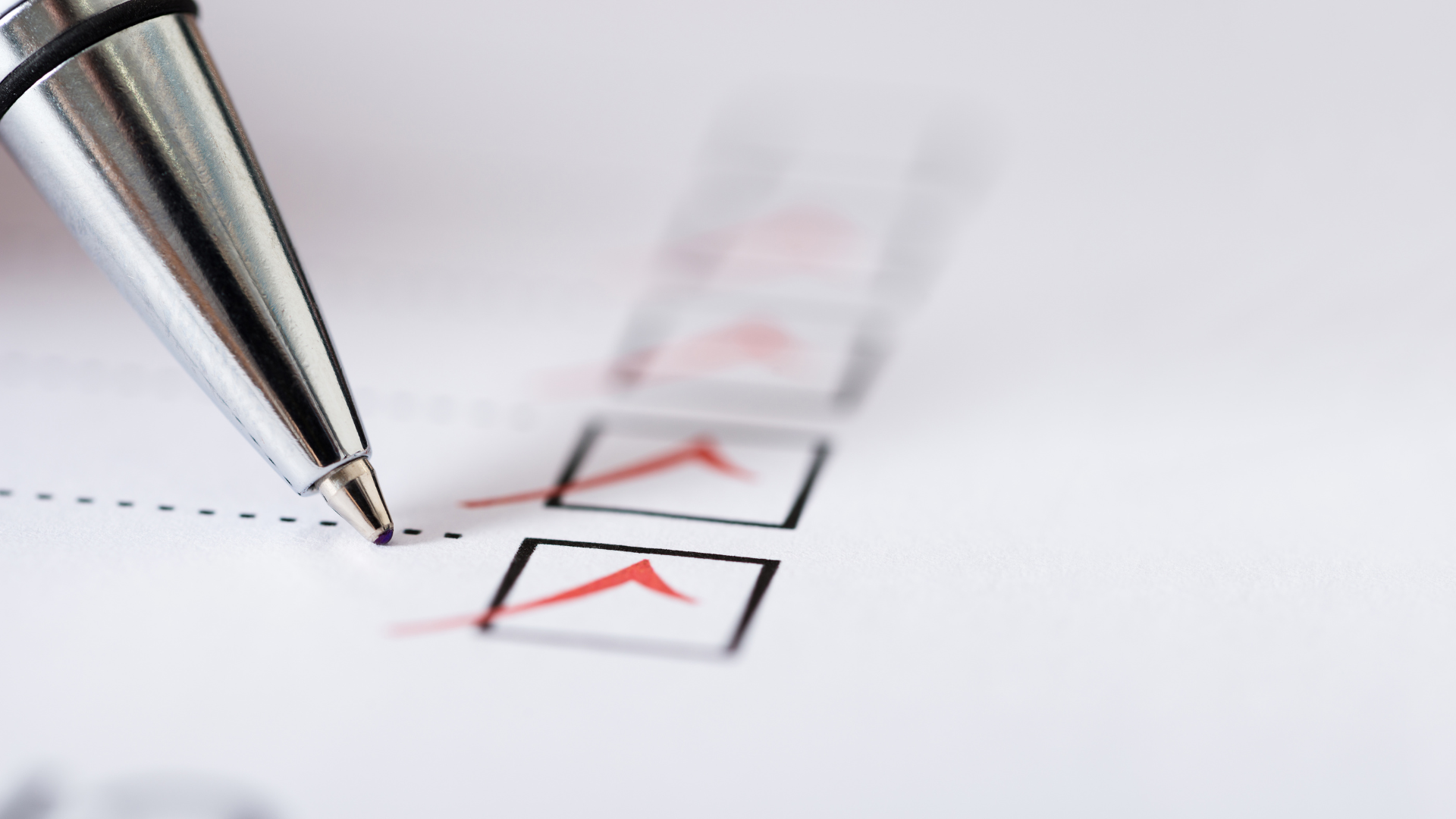 Close up of a pen checking boxes on a form.