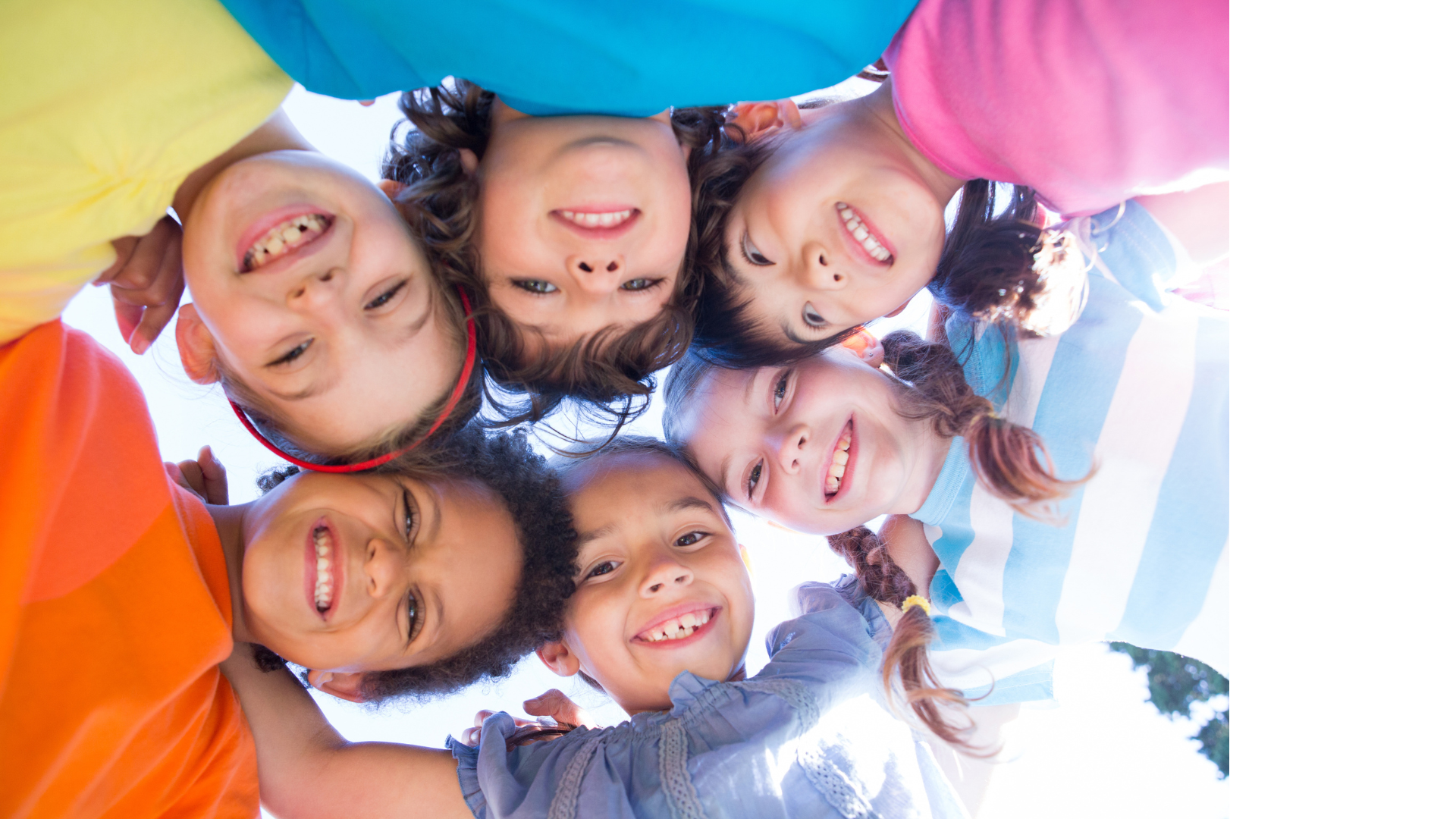 low angle looking up at circle of smiling children